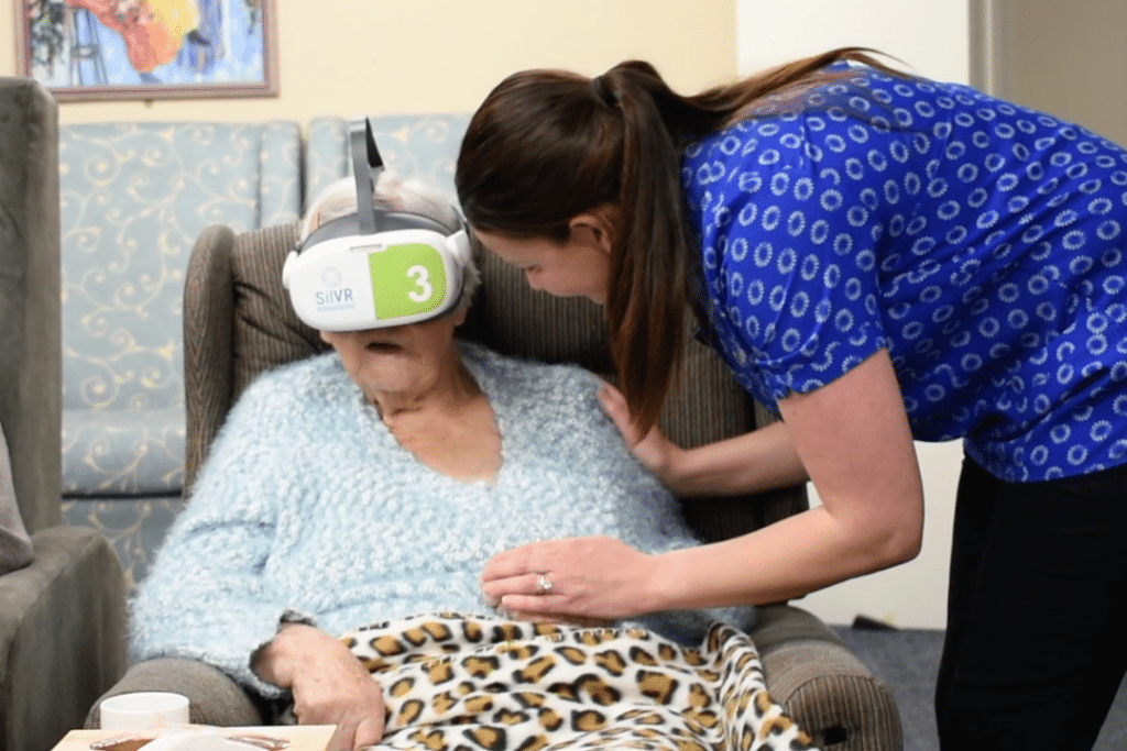 Resident participating in aged care VR engagement program with staff member